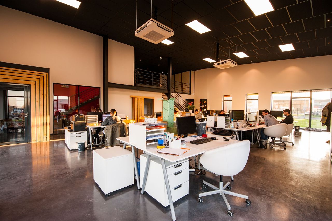 Open-plan commercial office with desks and large windows